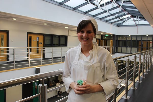 Joanne Barlow in Catering whites with one of her cupcakes.